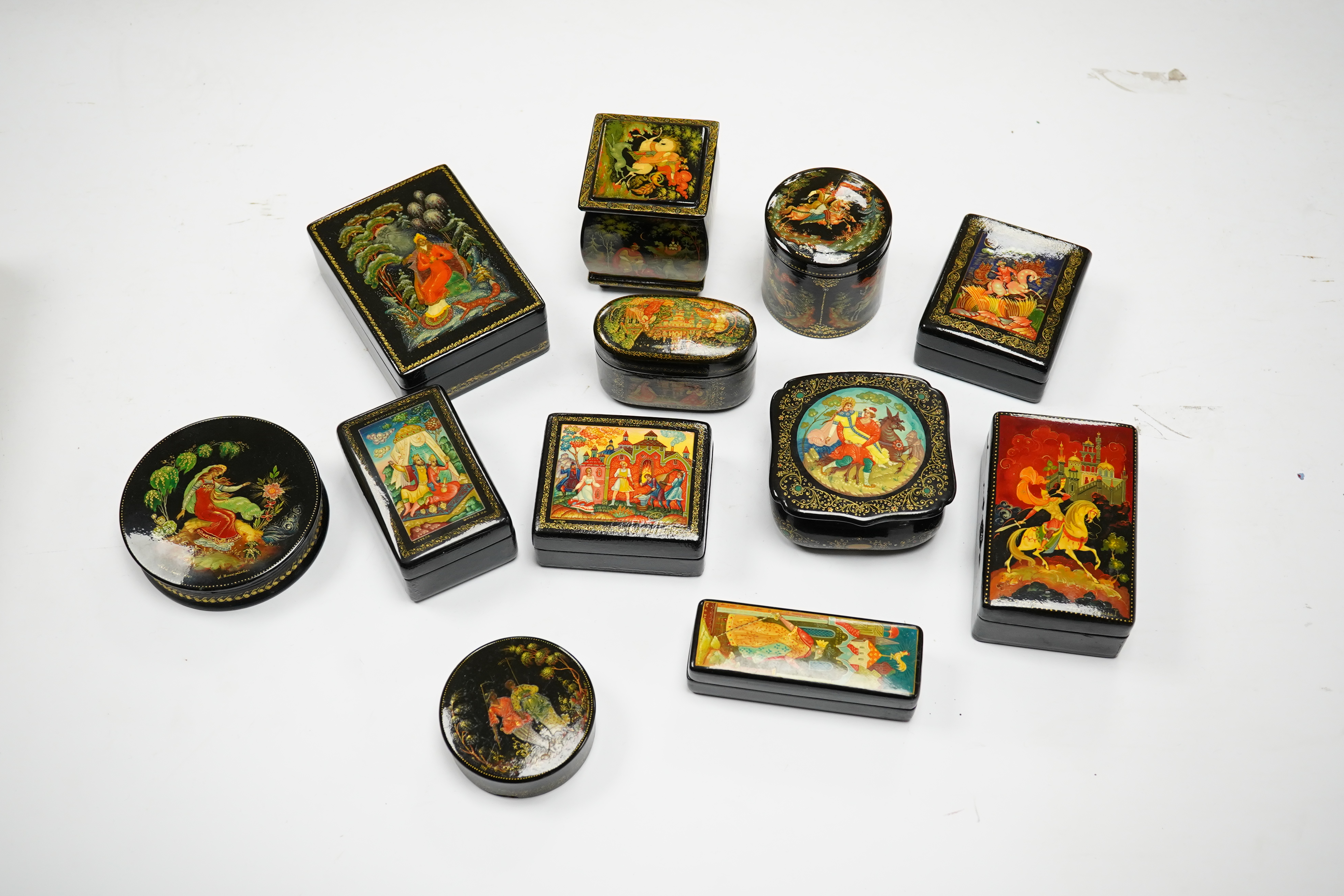 A quantity of Russian lacquer boxes decorated with figures and mythical scenes, largest 10cm in length. Condition - mostly good